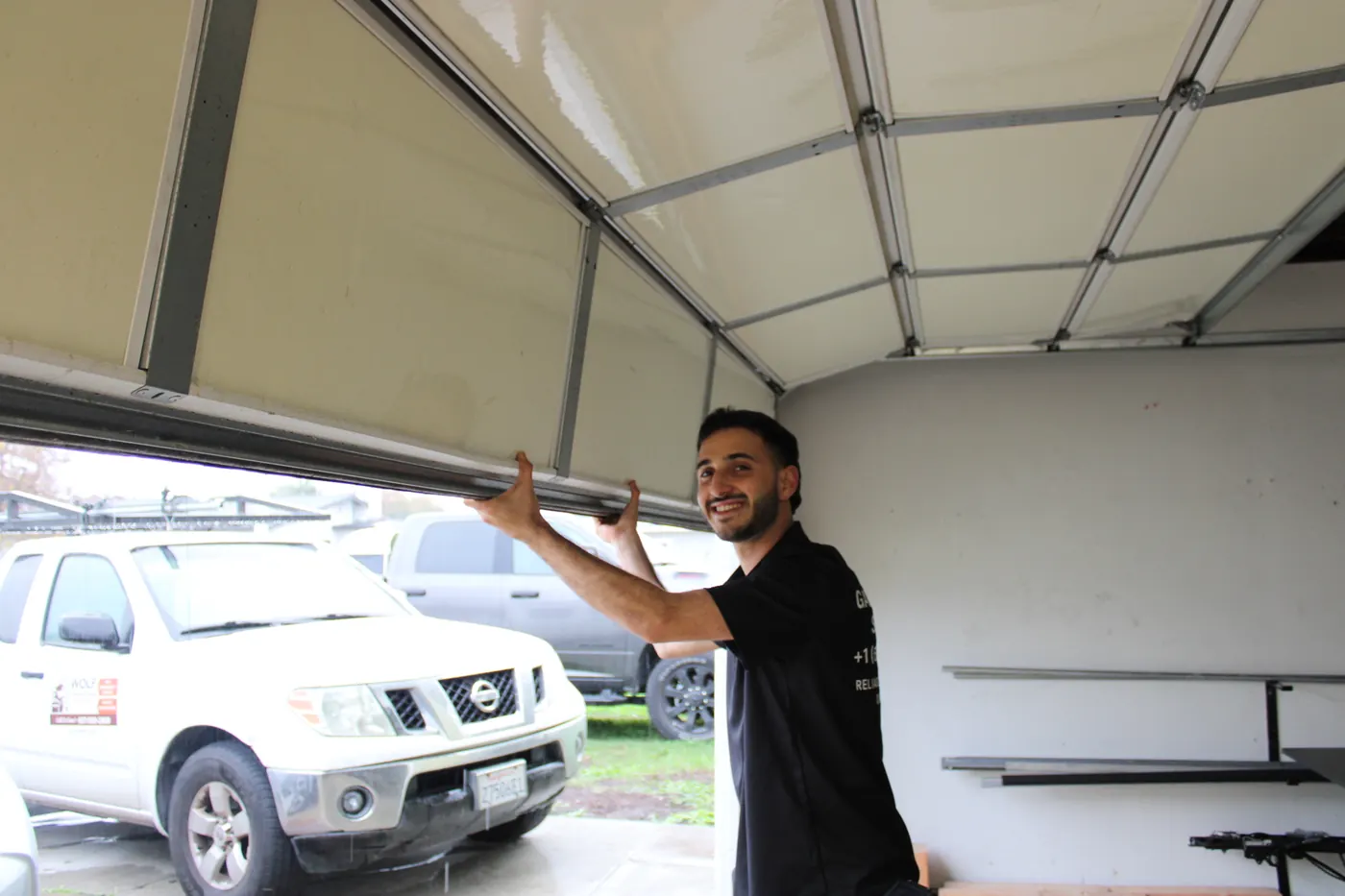 Wolf technician raising a sectional garage door by hand to check its balance