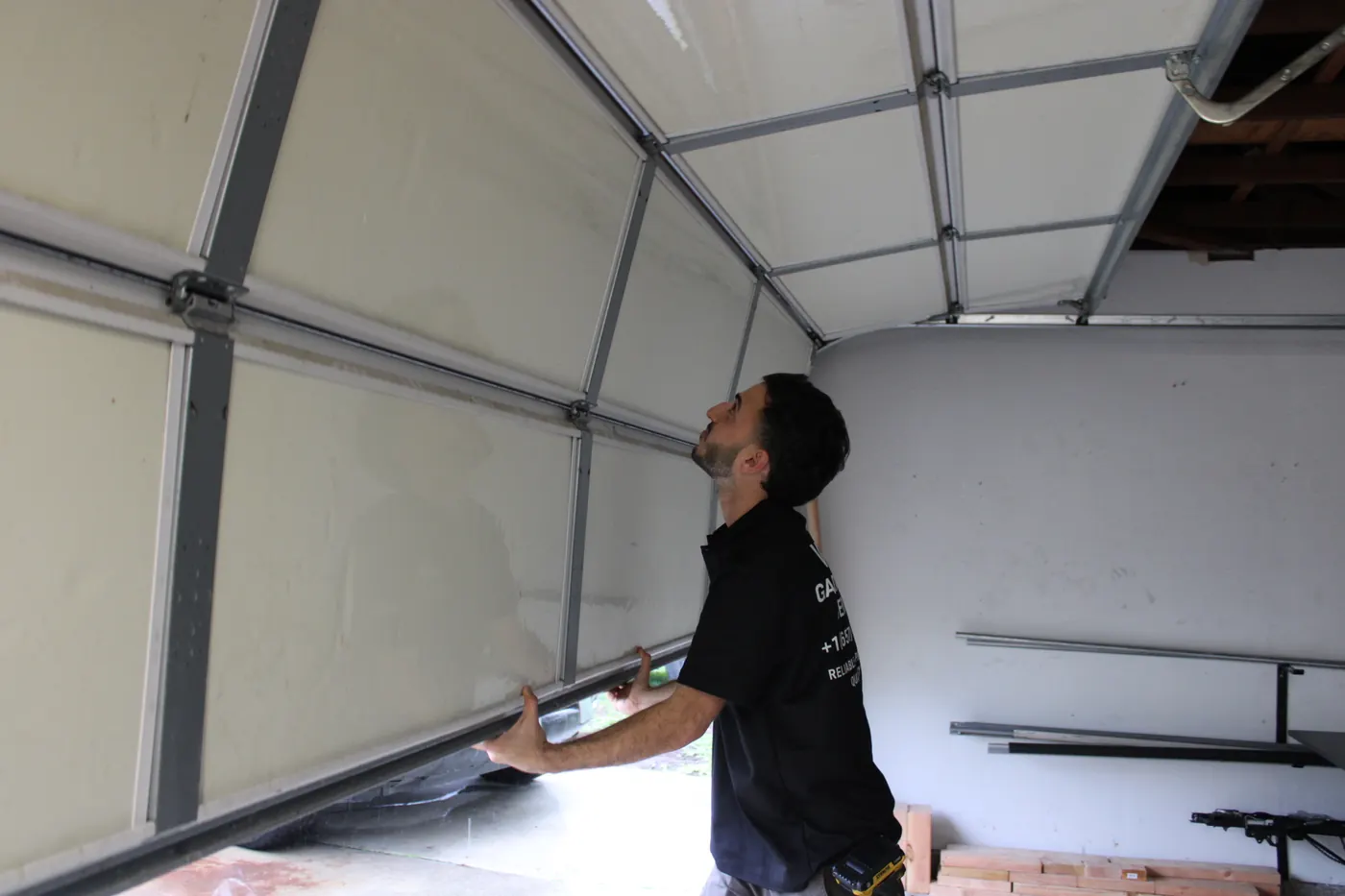 Technician checking the sections of an open garage door